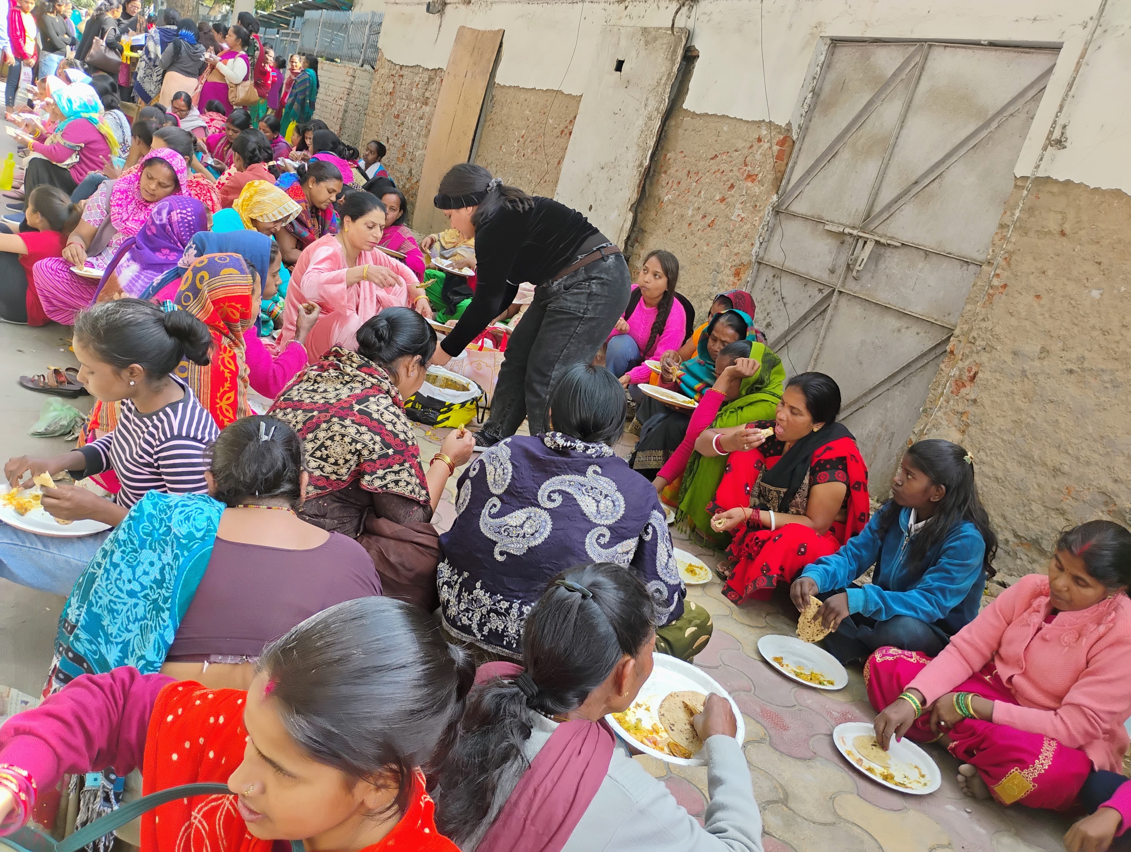 Community members gathered together in an urban settlement during a local support activity.
