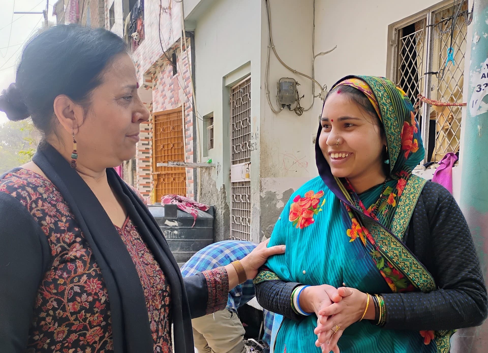 Two women in conversation during a neighborhood interaction.