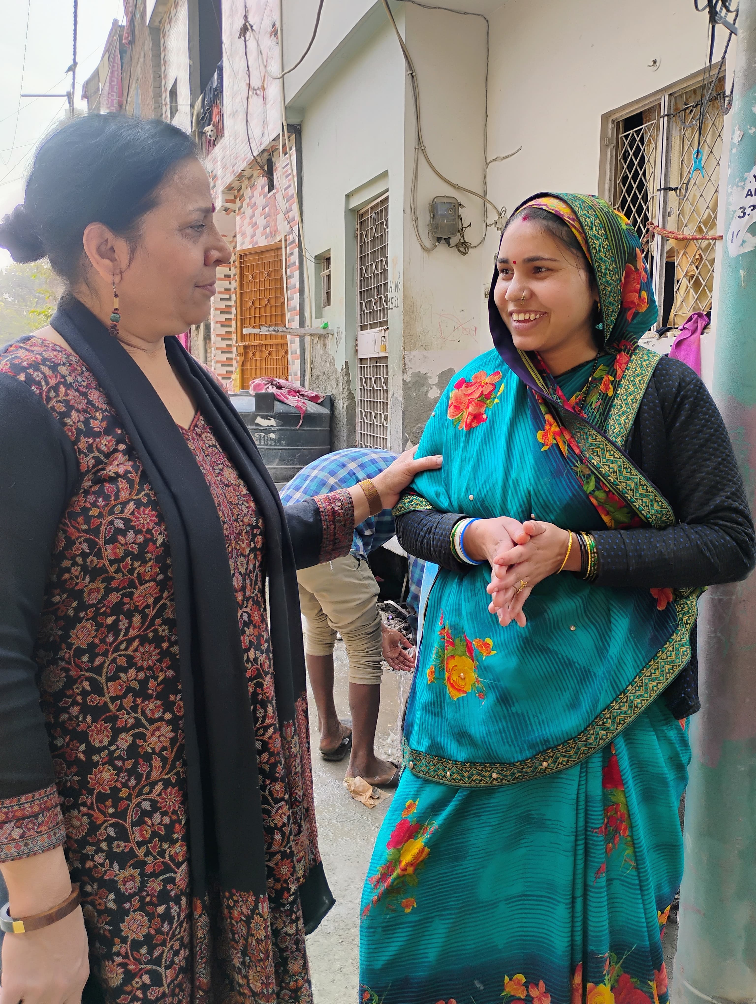 Two women speaking to each other in a neighborhood conversation.